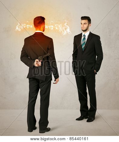 Angry businessman hiding a weapon behind his back 