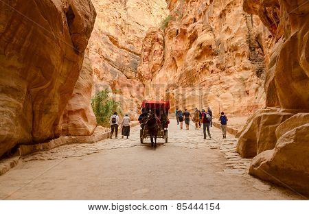 Tourists Ride In A Carriage And Go Through The Gorge In Petra, Jordan