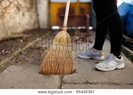 Woman Sweep Leaves And Soil Into Bin