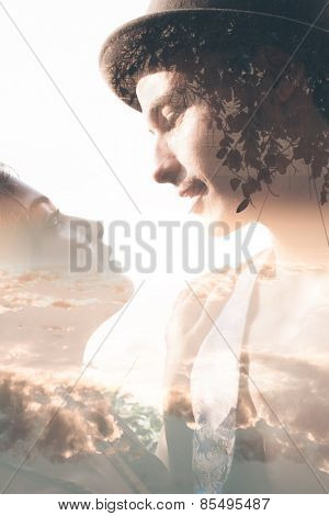 Double exposure portrait of tender couple combined with photograph of sunset