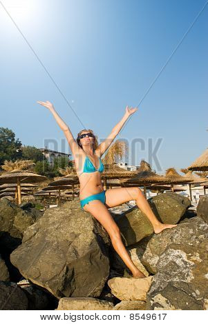 หญิงสาวอยู่บนหินบนชายหาด