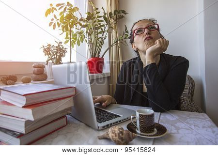 Young conceited arrogant woman sitting in the office with a laptop.