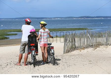 Family on a biking journey making a stop on the beach