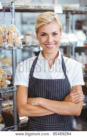 Selfassured female cook smiling in front of her bakery
