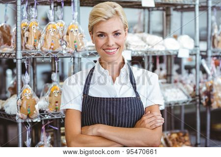 Selfassured female cook smiling in front of her bakery