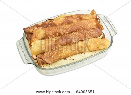 Pancakes filled with cottage cheese in the rectangular glass roasting pan on a light background