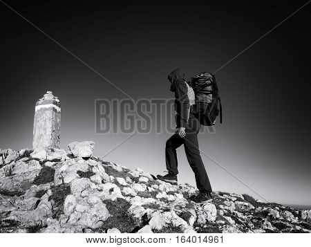 Adult Tourist With Backpack Walk On Mountain Peak. Last Step To Summit Stone