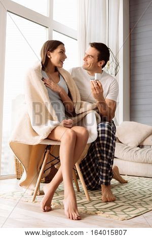 Romantic proposal. Happy handsome brunette man showing an engagement ring and making a proposal to his girlfriend while expressing his love to her