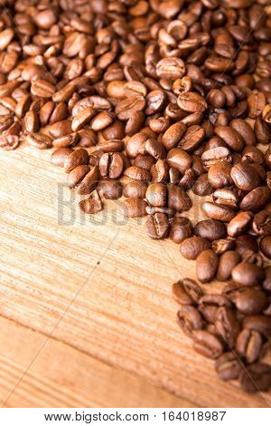 Roasted Coffee Beans Spread Over On Wooden Table.