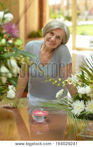 Portrait of a beautiful mature woman posing with flowers