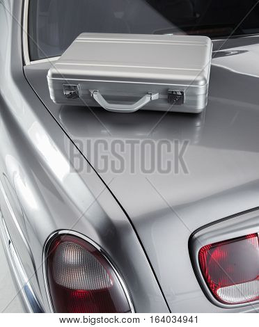 Metal luxery briefcase from a business man on the car boot of a luxery car