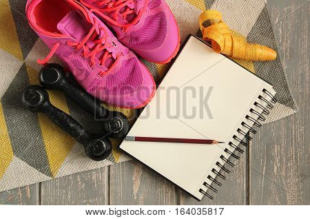 Trainers, dumbbells, ribbon, mat on floor. Stock photo Sporty mock up