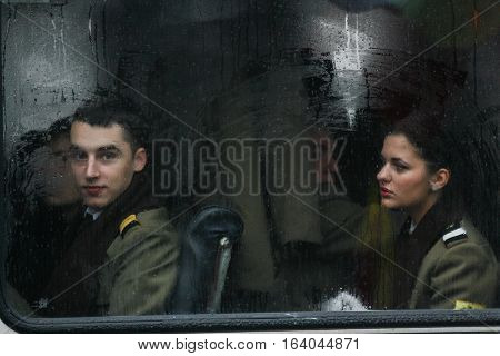 BUCHAREST ROMANIA - DECEMBER 1 2010: Military are seen behind a bus window during a military parade. More than 3000 soldiers and personnel from security agencies take part in the massive parades on National Day of Romania.