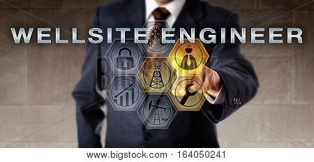 Recruitment manager in blue suit pressing WELLSITE ENGINEER on an interactive computer screen. Oil and gas industrial job metaphor for an engineering role in support of performance improvement.