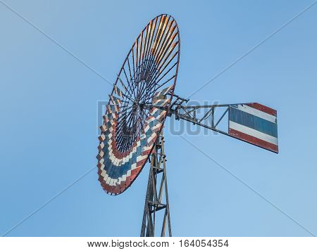 Old water pumping windmill and blue sky background , Thailand