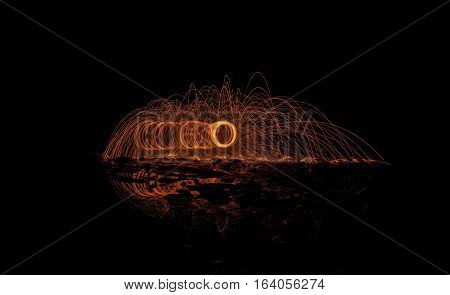 Burning steel wool on the beach at night