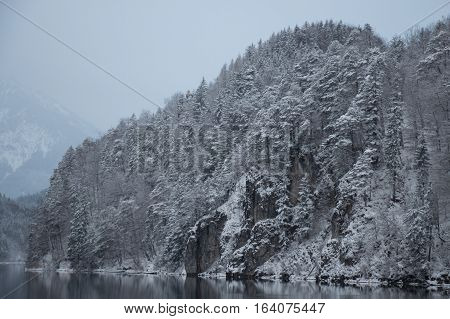 The view of white snowy mountain at Alpsee lake in winter time. Germany.