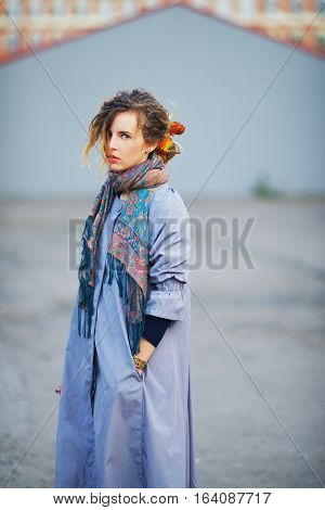 Young charming girl in a lavender cloak with a tippet about the neck on a walk through the city
