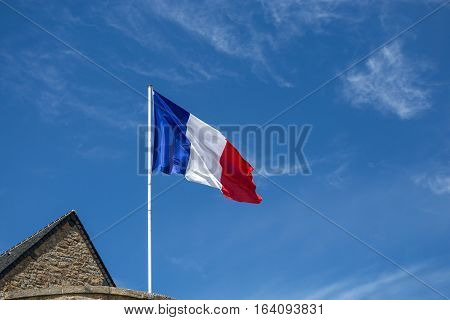 French flag fluttering in the wind on blue sky background