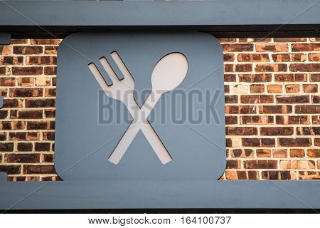 A sign with crossed spoon and fork.