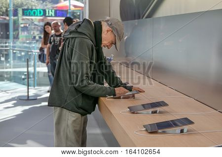 New York October 5 2016: An elderly man is looking at an iPad tablet in the Apple store on Manhattan's Upper West Side.