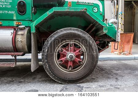 New York August 2 2016: A front wheel of a large garbage truck.