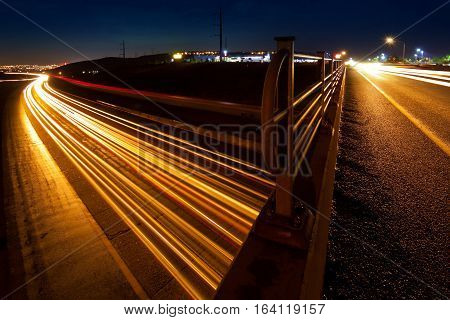 Busy car traffic trails on overpass and freeway at night