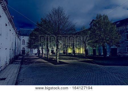 Patio of the Belgian house with park. The old pavement in St Hubert Belgium at night.