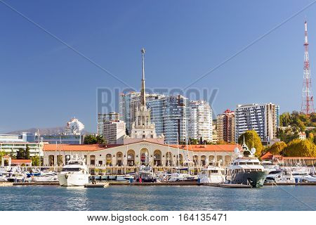 Sochi Russia - November 1 2015: View from water at Sochi sea port. Luxury yachts and private boats moored at pier. In background architecture modern resort town hotels and sanatoriums. Marine station complex Port. Krasnodarskiy kray Russia