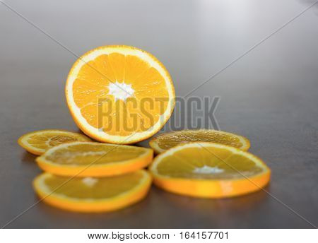 deliciously sweet ripe orange cut into slices laid on a shiny bar board
