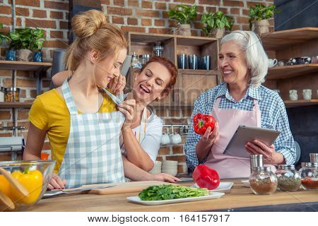 Smiling family of three cooking together in kitchen
