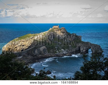 Gastelugache -  island on  coast of  Bay of Biscay belonging to  municipality of Bermeo, Basque Country.  Island is connected to  mainland by  man-made bridge that goes into  winding staircase that spans 237 degrees.