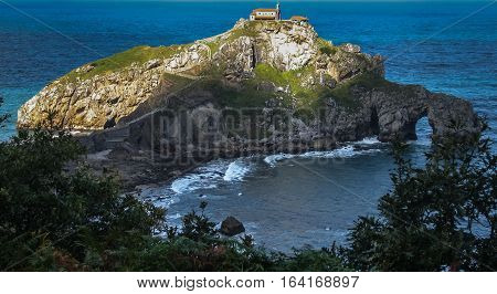 Gastelugache -  island on  coast of  Bay of Biscay belonging to  municipality of Bermeo, Basque Country.  Island is connected to  mainland by  man-made bridge that goes into  winding staircase that spans 237 degrees.