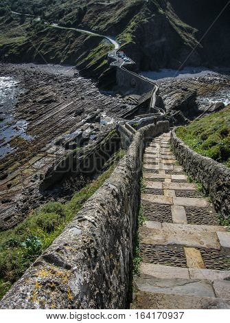 Gastelugache -  island on  coast of  Bay of Biscay belonging to  municipality of Bermeo, Basque Country.  Island is connected to  mainland by  man-made bridge that goes into  winding staircase that spans 237 degrees.