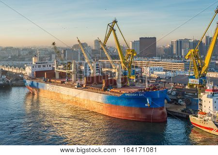 Casablanca Morocco - December 8 2016: Cargo vessel Discovery Bay (Bulk Carrier) early in the morning at dawn in the seaport of Casablanca Morocco. The scene with harbor cranes and ships in the port.