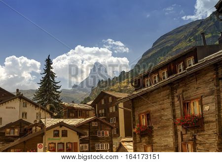 Matterhorn surrounded with clouds in front of Zermatt village houses by day, Zermatt, Switzerland