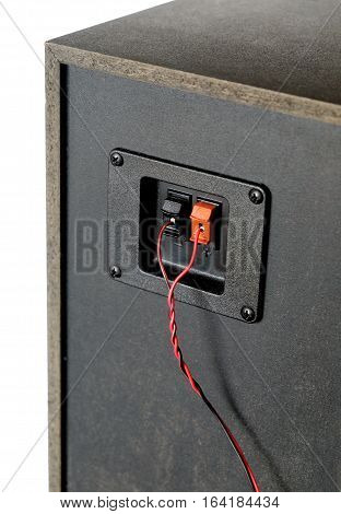 Red and black twisted wire connected to cable connection socket on rear side speaker system box side view vertical photo isolated closeup