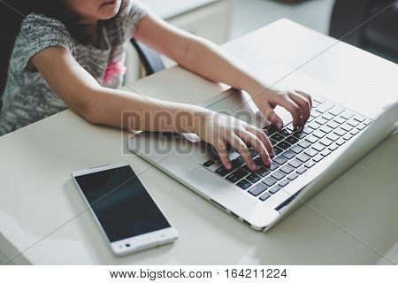 Cute asian little girl using laptop at home . Seleted focus.
