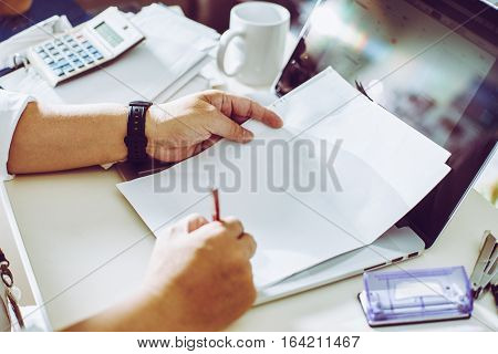 Businessman holding a pen for working on his plan project