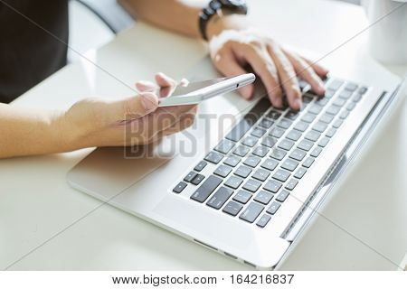 Young man hand using smart phone and laptopclose up Seleted focus.