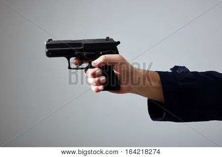 Closeup view of man's hand aiming with gun.