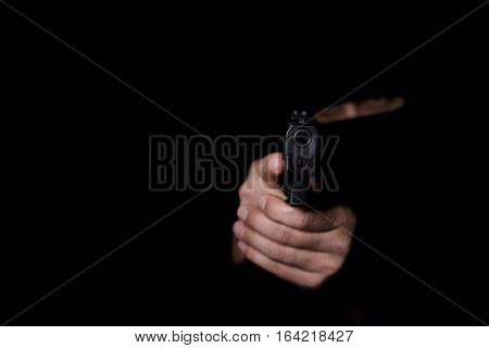 Closeup view of man's hands aiming with gun.