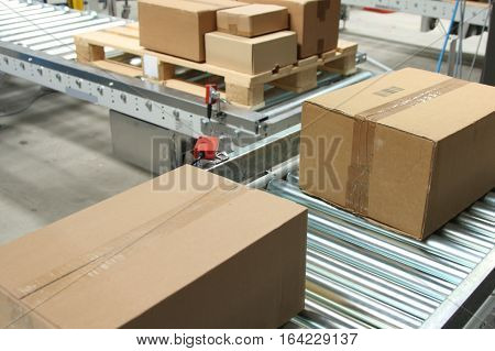 Boxes on conveyor belt in logistics distribution warehouse.