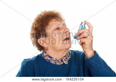 Picture of an elderly woman using an inhaler beacuse of an asthma attack