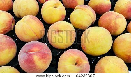 Fresh peaches on supermarket shelf. These are in season and are rippened, ready for consumption.