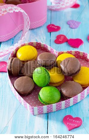 Frame Valentine's Day Or A Birthday, Mother's Day. Gifts Makarons Cake With Heart On A Blue Wooden B