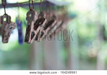 Clothes pegs or clothespins hang on a cord. Plastic clothes pegs on a washing line.(selective focus)