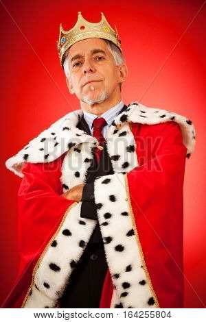 senior man wearing a business suit and a king's crown