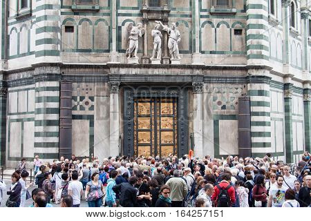 FLORENCE ITALY - APRIL 29 2016: tourists look on East doors of Baptistery (Battistero di San Giovanni Baptistery of Saint John) the doors are copy of Gates of Paradise made by Lorenzo Ghiberti
