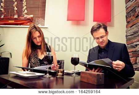 adult couple reading the menu in a restaurant